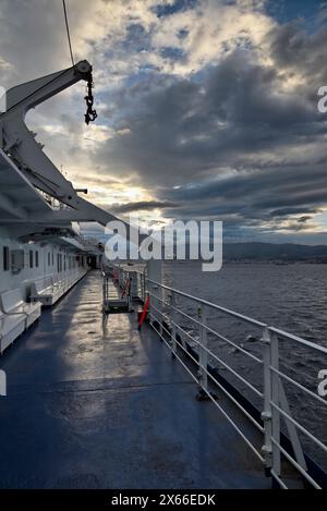 Italia, Calabria, vista del Canale di Sicilia e della costa siciliana al tramonto da uno dei tanti traghetti che collegano la Calabria alla Sicilia Foto Stock