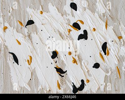 Immagine di sfondo dipinta con tratti di pennello e incollaggio di strutture su un quadro. Texture casuale con macchie nere e dorate. Design creativo astratto. Foto Stock