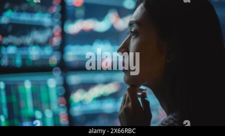Primo piano Ritratto di Financial Analyst che lavora su un computer con workstation multi-monitor con azioni, materie prime e grafici Exchange Market in tempo reale. Donna d'affari al lavoro nell'Agenzia di investimento. Foto Stock