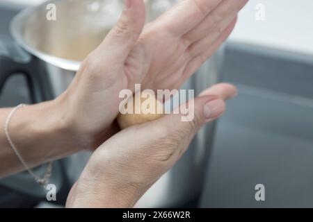 tenere una patata sopra una pentola, prepararsi a cucinare in una cucina con luce soffusa e naturale Foto Stock