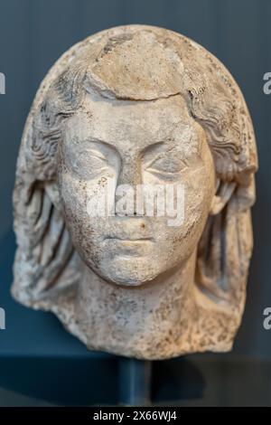 Primo piano sulla testa dell'antica statua romana in marmo di una giovane donna sorridente Foto Stock