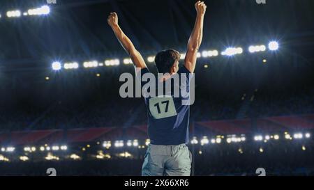 Ritratto dell'atleta professionista maschile che celebra con gioia il nuovo record per la vittoria del campionato sportivo. Determinato sportivo di successo che solleva le armi acclamato per la vittoria della medaglia d'oro. Foto Stock