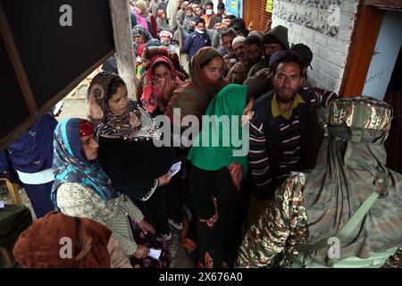 Shopify, India. 12 maggio 2024. Le persone in coda per votare nella quarta fase delle elezioni di Lok Sabha nel distretto di Shopify del Kashmir meridionale. Il voto per le elezioni di Lok Sabha del 2024 è in corso nel Shopify del Jammu e del Kashmir nella quarta fase. Questa è la prima grande elezione in Kashmir dall'abrogazione dell'articolo 370, che ha concesso uno status speciale al precedente stato del Jammu e del Kashmir. Ben 24 candidati sono nella mischia nel collegio di Srinagar Lok Sabha. (Foto di Nisar UL Haq Allaie/Pacific Press) credito: Pacific Press Media Production Corp./Alamy Live News Foto Stock