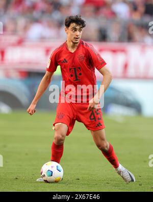 MONACO DI BAVIERA, GERMANIA - 12 MAGGIO: Aleksandar Pavlovic del Bayern Muenchen corre con un pallone durante la partita di Bundesliga tra il Bayern München e il VfL Wolfsburg all'Allianz Arena il 12 maggio 2024 a Monaco di Baviera, Germania. © diebilderwelt / Alamy Stock Foto Stock