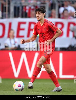 MONACO DI BAVIERA, GERMANIA - 12 MAGGIO: Aleksandar Pavlovic del Bayern Muenchen corre con un pallone durante la partita di Bundesliga tra il Bayern München e il VfL Wolfsburg all'Allianz Arena il 12 maggio 2024 a Monaco di Baviera, Germania. © diebilderwelt / Alamy Stock Foto Stock