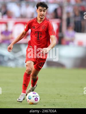 MONACO DI BAVIERA, GERMANIA - 12 MAGGIO: Aleksandar Pavlovic del Bayern Muenchen corre con un pallone durante la partita di Bundesliga tra il Bayern München e il VfL Wolfsburg all'Allianz Arena il 12 maggio 2024 a Monaco di Baviera, Germania. © diebilderwelt / Alamy Stock Foto Stock