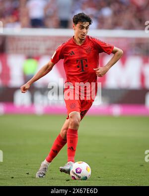 MONACO DI BAVIERA, GERMANIA - 12 MAGGIO: Aleksandar Pavlovic del Bayern Muenchen corre con un pallone durante la partita di Bundesliga tra il Bayern München e il VfL Wolfsburg all'Allianz Arena il 12 maggio 2024 a Monaco di Baviera, Germania. © diebilderwelt / Alamy Stock Foto Stock