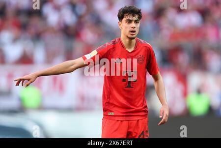 MONACO DI BAVIERA, GERMANIA - 12 MAGGIO: Aleksandar Pavlovic del Bayern Muenchen guarda durante la partita di Bundesliga tra FC Bayern München e VfL Wolfsburg all'Allianz Arena il 12 maggio 2024 a Monaco di Baviera, Germania. © diebilderwelt / Alamy Stock Foto Stock