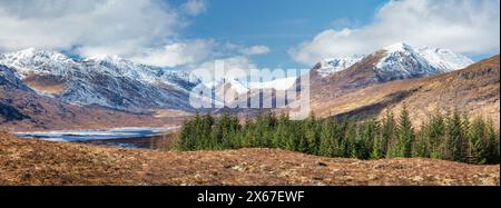 Montagne ricoperte di neve intorno a Loch Loyne e lontane cinque sorelle a Glenshiel. panoramica Foto Stock