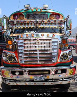 "Chicken Bus". Antigua, Guatemala. Scuolabus americano in pensione ristrutturato nella stazione degli autobus vicino al mercato municipale. Vivace, individualizzato, famoso. Foto Stock