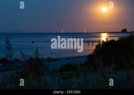 Luna piena sul ponte Storebaelt con riflessi nel Mar Baltico, Dalby, Danimarca Foto Stock