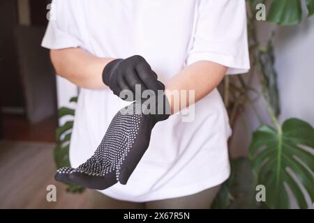 La mano che indossa un guanto di gomma. Simbolo della sicurezza sul lavoro. Trasmette approvazione e comunicazione positiva. Soddisfazione e protezione. Mettendosi a portata di mano Foto Stock
