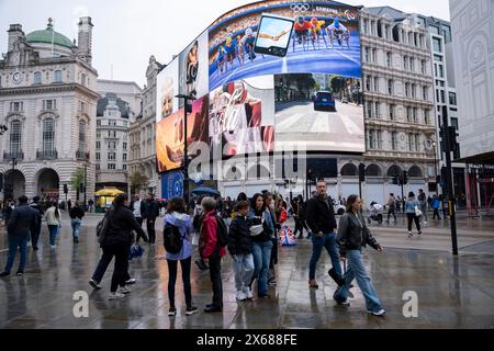 Persone sotto la pioggia al Piccadilly Circus il 6 maggio 2024 a Londra, Regno Unito. Piccadilly Circus è un famoso incrocio stradale e uno spazio pubblico nel West End di Londra, molto popolare tra i turisti. Foto Stock