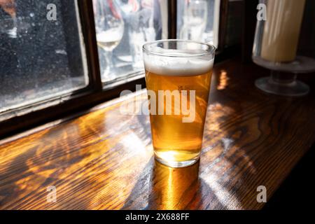 Pinta di birra inglese su un tavolo da pub il 9 maggio 2024 a Londra, Regno Unito. I prezzi della birra nel Regno Unito sono aumentati con un aumento vertiginoso dei prezzi per pinta durante la crisi energetica e che ha aggravato la crisi del costo della vita. Foto Stock