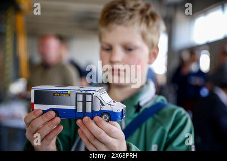 Cracovia, Polonia. 13 maggio 2024. Un ragazzo possiede un modello di autobus pubblico mentre Cracovia introduce un nuovo autobus a idrogeno Mercedes-Benz eCitaro Fuel Cell nel suo trasporto pubblico alla conferenza stampa a Cracovia, in Polonia, il 13 maggio 2024. Il nuovo autobus alimentato a idrogeno si unirà alla flotta di Cracovia su una linea di autobus regolare. L'autobus viene trasportato da una stazione mobile. Cracovia prevede di far crescere la flotta di idrogeno. Crediti: Dominika Zarzycka/Alamy Live News crediti: Dominika Zarzycka/Alamy Live News Foto Stock