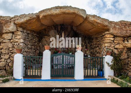 EN el paseo entre Fornells y su torre de defensa se encuentra una cueva Natural convertida en ermita dedicada a la Virgen de Lourdes. Minorca, España Foto Stock