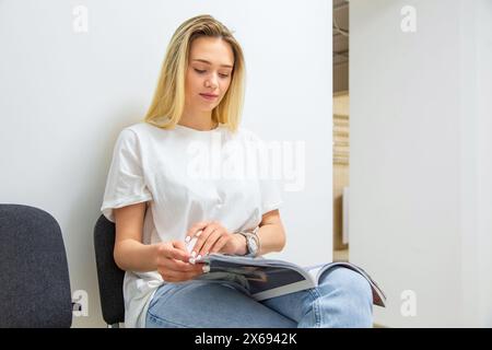 La bella ragazza bionda caucasica sta venendo in un salone spa, accolta dalla receptionist bruna Foto Stock