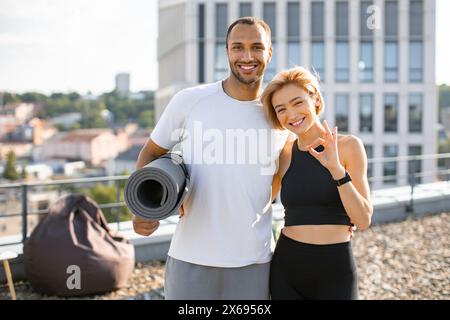 Ritratto di una famiglia felice che fa sport in estate contro il paesaggio urbano. Foto Stock