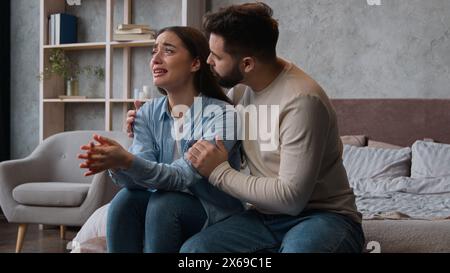 Caucasian man apologizing husband calming anxious annoyed wife ask forgiveness after family conflict crying tears woman emotional complain listen to Stock Photo