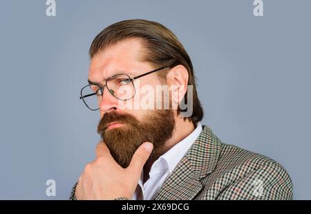 Il ritratto ravvicinato di un uomo d'affari fiducioso e premuroso con gli occhiali prende decisioni, pensa al futuro, pianificando una nuova startup. Espressione pensiva Foto Stock