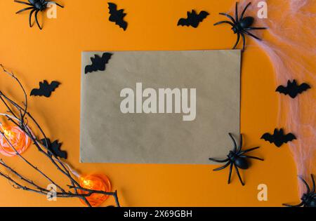 Decorazioni di Halloween con zucche, pipistrelli, ragnatela, insetti su sfondo arancione. Scheda party con spazio di copia. Foto Stock