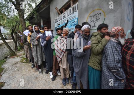 Srinagar, India. 13 maggio 2024. Gli uomini fanno la fila per votare in un seggio elettorale durante la quarta fase di votazione alle elezioni generali in India, a Ganderbal il 13 maggio 2024. (Foto di Mubashir Hassan/Pacific Press) credito: Pacific Press Media Production Corp./Alamy Live News Foto Stock