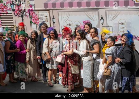 Le donne ben vestite posano per le foto di fronte al party bus "Tea around Town" sulla 42nd St. A Midtown Manhattan in una giornata di sole, New York, USA Foto Stock