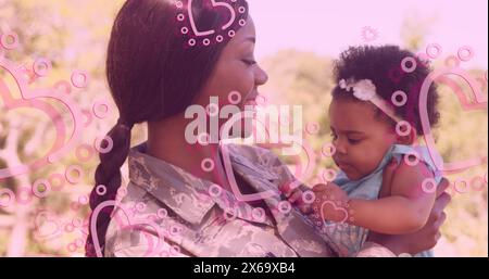 Immagine di cuori su felice madre soldato afroamericano che abbraccia figlia Foto Stock