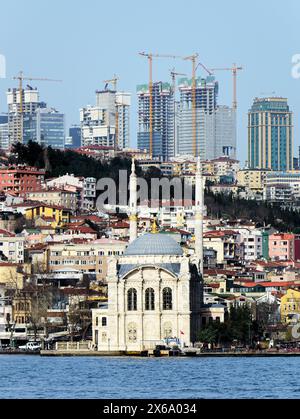 Moschea di Ortakoy, Istanbul, Turchia, vista dal Bosforo. Completato nel 1856. Edificio alto e moderno alle spalle Foto Stock