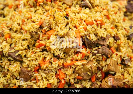 Piatto nazionale di cucina orientale dei paesi dell'Asia centrale pilaf (plov) con carne di maiale e di manzo Foto Stock