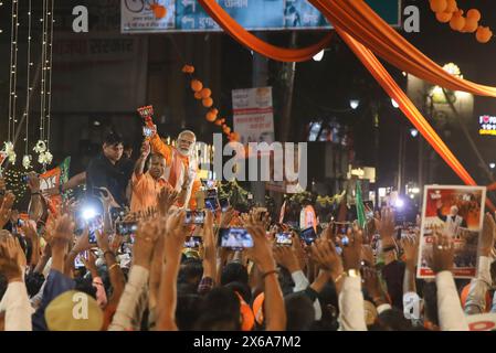 Varanasi, India. 13 maggio 2024. Il primo ministro indiano Narendra modi e il primo ministro dell'Uttar Pradesh Yogi Adityanath si rivolgono ai sostenitori del Bharatiya Janata Party (BJP) durante un roadshow come parte di una manifestazione elettorale. Credito: SOPA Images Limited/Alamy Live News Foto Stock