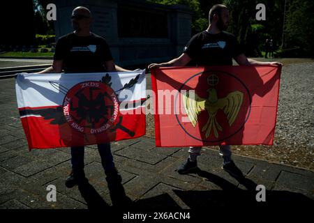 Due uomini sono visti con una bandiera dell'organizzazione nazionalista paramilitare e filo-russa Zadruzny Krag a Varsavia, in Polonia, il 9 maggio 2024. Foto Stock