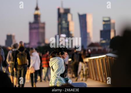 Varsavia, Polonia. 13 maggio 2024. Le persone sono viste camminare lungo il nuovo ponte pedonale e ciclabile attraverso il fiume Vistola. Il nuovo ponte pedonale e ciclabile sul fiume Vistola è lungo 452 metri e collega il centro della città con il quartiere di Praga. È stato inaugurato il 28 marzo 2024 ed è diventato molto popolare tra i residenti della città e i turisti. Dal ponte, pedoni e ciclisti possono ammirare la vista del fiume Vistola e di Varsavia, compreso il centro storico, patrimonio dell'umanità dell'UNESCO. Credito: SOPA Images Limited/Alamy Live News Foto Stock