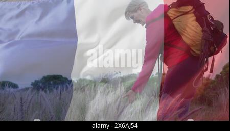 Immagine della bandiera della francia sopra felice donna caucasica che cammina sul campo Foto Stock