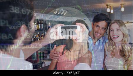 Immagine dell'elaborazione dei dati su un cameriere caucasico che scatta foto a un gruppo di amici in un bar Foto Stock