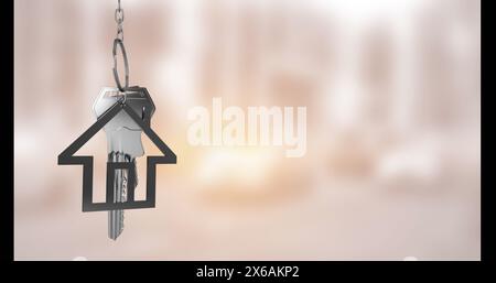 Immagine della chiave con portachiavi della casa su sfondo sfocato Foto Stock