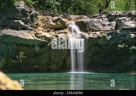 Lunga esposizione della cascata su una scogliera rocciosa in una profonda piscina verde del fiume Mirna in Croazia Foto Stock