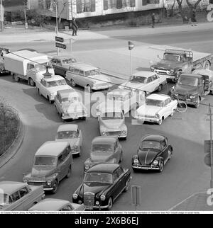 Guida negli anni '1960 Un incrocio in cui si formano auto provenienti da strade diverse e una coda di auto. Svezia 1962 Foto Stock