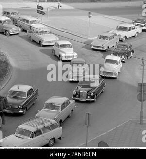 Guida negli anni '1960 Un incrocio in cui si formano auto provenienti da strade diverse e una coda di auto. Svezia 1962 Foto Stock