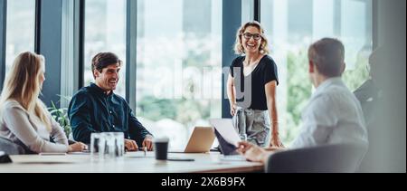 Gruppo di colleghi impegnati in una discussione durante una riunione di lavoro in una sala conferenze. Uomini d'affari felici, uomini e donne, collaborando e W Foto Stock