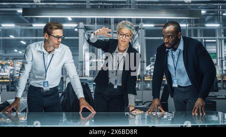 Team diversificato di ingegneri automobilistici che lavorano in ufficio presso la fabbrica automobilistica. I designer industriali parlano e fanno gesti di spostamento di oggetti invisibili nella realtà aumentata. Ottimo modello per i tuoi oggetti AR Foto Stock