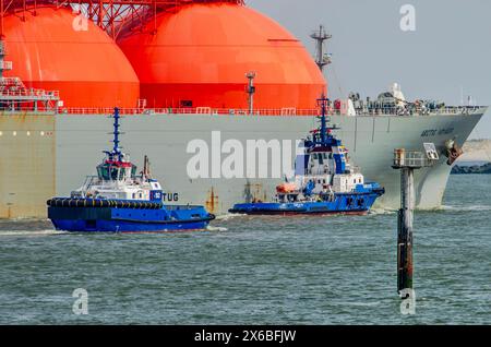 Rotterdam, Paesi Bassi, 13 aprile 2024: Due rimorchiatori in procinto di collegarsi ad una grande cisterna GNL in viaggio verso il terminal Foto Stock