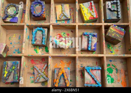 Gioco per bambini, lettere dell'alfabeto formate con vecchie catene di biciclette Foto Stock