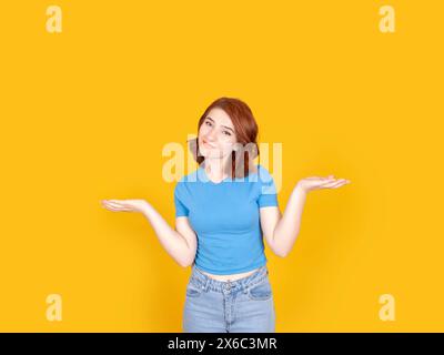 Non ne ho idea, ritratto di una giovane donna caucasica con capelli di corvo rosso che si scaglia sulle spalle, dice che non ne ho idea. La ragazza confusa non sa rispondere. Foto Stock