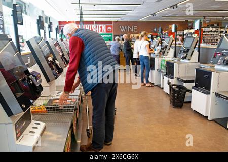 Persone clienti acquirenti anziani anziani anziani retrovisione con scanner di cassa self sevice presso il supermercato M&S, sala ristorazione Regno Unito KATHY DEWITT Foto Stock