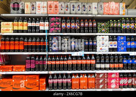 File di bottiglie di plastica bevande analcoliche di vari marchi Coke Pepsi coca cola sugli scaffali dei supermercati in vendita nel supermercato Co Op UK KATHY DEWITT Foto Stock