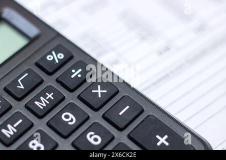 Primo piano di una calcolatrice, di un dispositivo di input periferico, sopra un foglio di carta, di un'apparecchiatura da ufficio spesso utilizzata con una tastiera per computer o un personal com Foto Stock