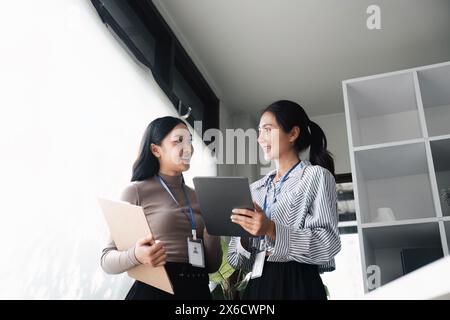 Professionisti aziendali che discutono della strategia con tablet digitali e appunti. Concetto di collaborazione e pianificazione Foto Stock