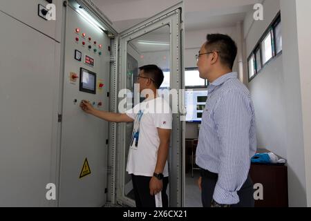 (240514) -- DONGCHUAN, 14 maggio 2024 (Xinhua) -- i ricercatori Zhou Gongdan (R) e Zhong Wei lavorano al centro di controllo della piattaforma di esperimenti di simulazione dinamica su larga scala per i disastri montani presso la stazione di Dongchuan nel distretto di Dongchuan di Kunming, nella provincia di Yunnan, nella Cina sud-occidentale, 8 maggio 2024. La gola di Jiangjiagou, situata nel bacino del fiume Xiaojiang, era una frequente frana. Nel 1961, una stazione di osservazione e ricerca dei flussi di detriti, nota come stazione di Dongchuan, è stata fondata nell'area di Jiangjiagou. Da allora, diverse generazioni di ricercatori hanno osservato e stu Foto Stock