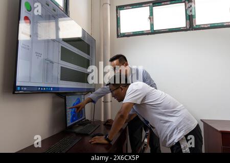 (240514) -- DONGCHUAN, 14 maggio 2024 (Xinhua) -- i ricercatori Zhou Gongdan (indietro) e Zhong Wei lavorano al centro di controllo della piattaforma di esperimenti di simulazione dinamica su larga scala per i disastri in montagna alla stazione di Dongchuan nel distretto di Dongchuan di Kunming, nella provincia di Yunnan, nella Cina sud-occidentale, 8 maggio 2024. La gola di Jiangjiagou, situata nel bacino del fiume Xiaojiang, era una frequente frana. Nel 1961, una stazione di osservazione e ricerca dei flussi di detriti, nota come stazione di Dongchuan, è stata fondata nell'area di Jiangjiagou. Da allora, diverse generazioni di ricercatori hanno osservato e. Foto Stock